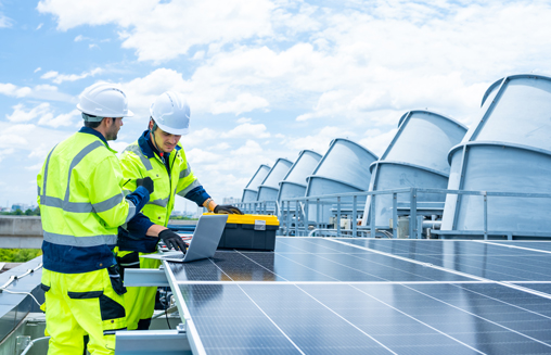 Two engineers inspecting solar panels on rooftop